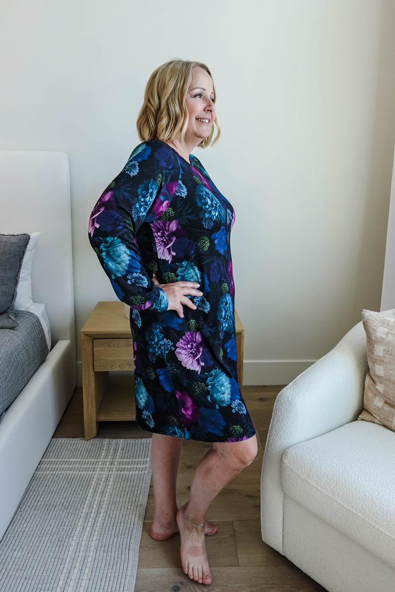 blonde woman standing in long sleeve nightgown in deep navy floral print