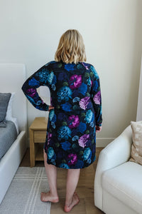 blonde woman standing in long sleeve nightgown in deep navy floral print