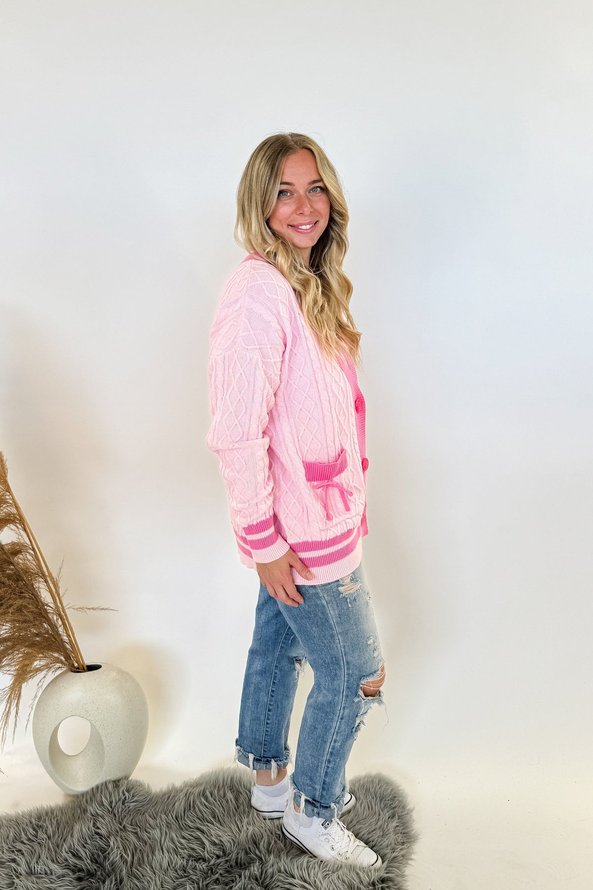 monochrome pink varsity style letterman cardigan with button front and pockets with bows on them