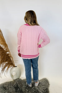 monochrome pink varsity style letterman cardigan with button front and pockets with bows on them